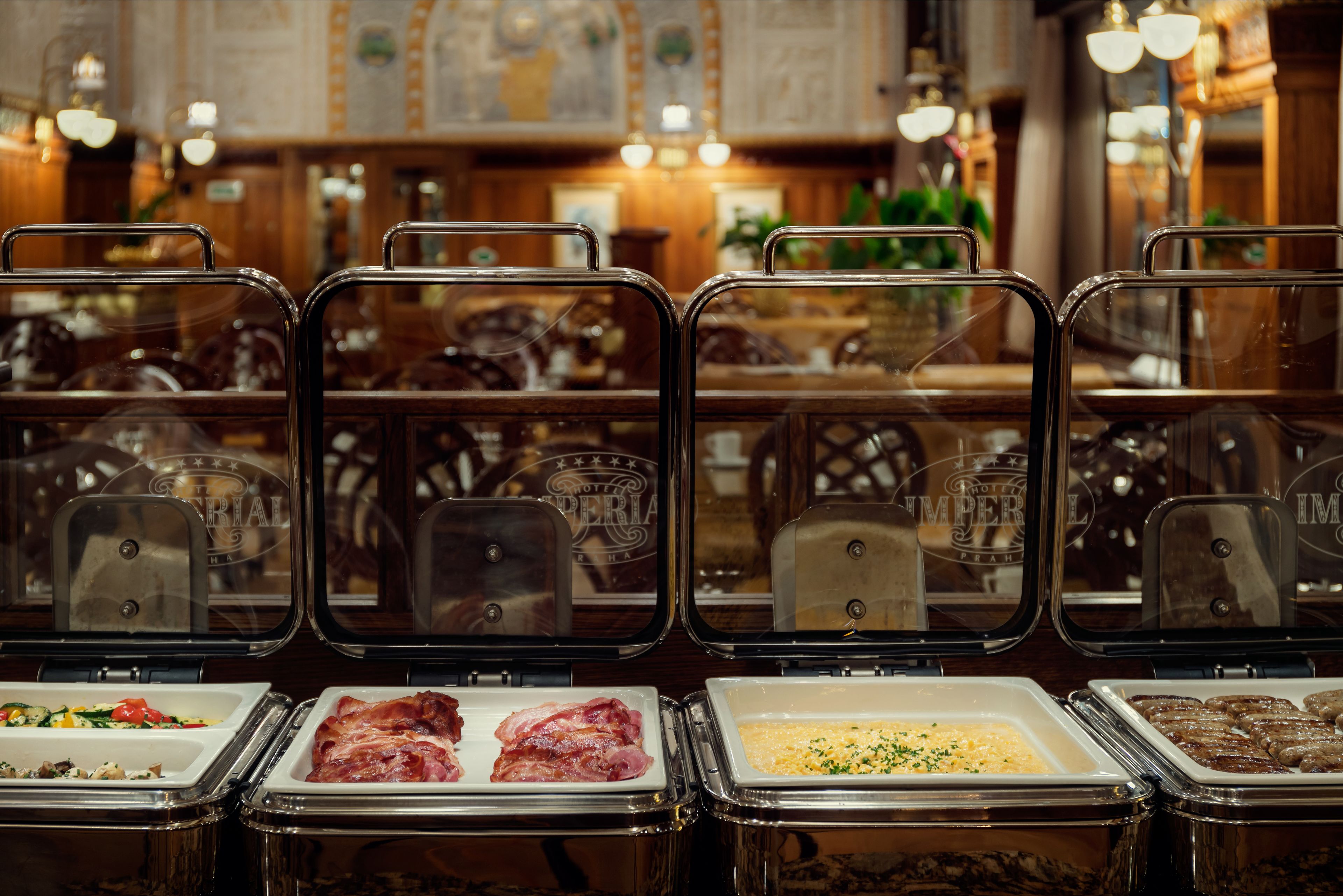 A buffet area with various food options in clear containers, including meats and salads.