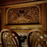 Un panel de madera tallado sobre una mesa con sillas.
