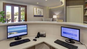 A reception desk with two monitors, a telephone, and a keyboard. - FAVIGNANA HOTEL Concept Holiday (Favignana)