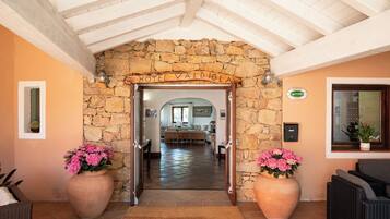 A hotel entrance with a stone archway, a reception desk, and a view into the lobby.
