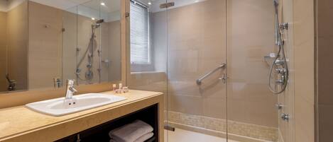 A modern bathroom with a glass-enclosed shower, a sink with a mirror, and a towel rack.