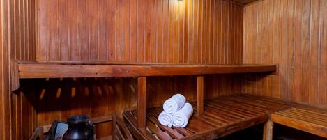 A wooden sauna with benches and a bench with towels.