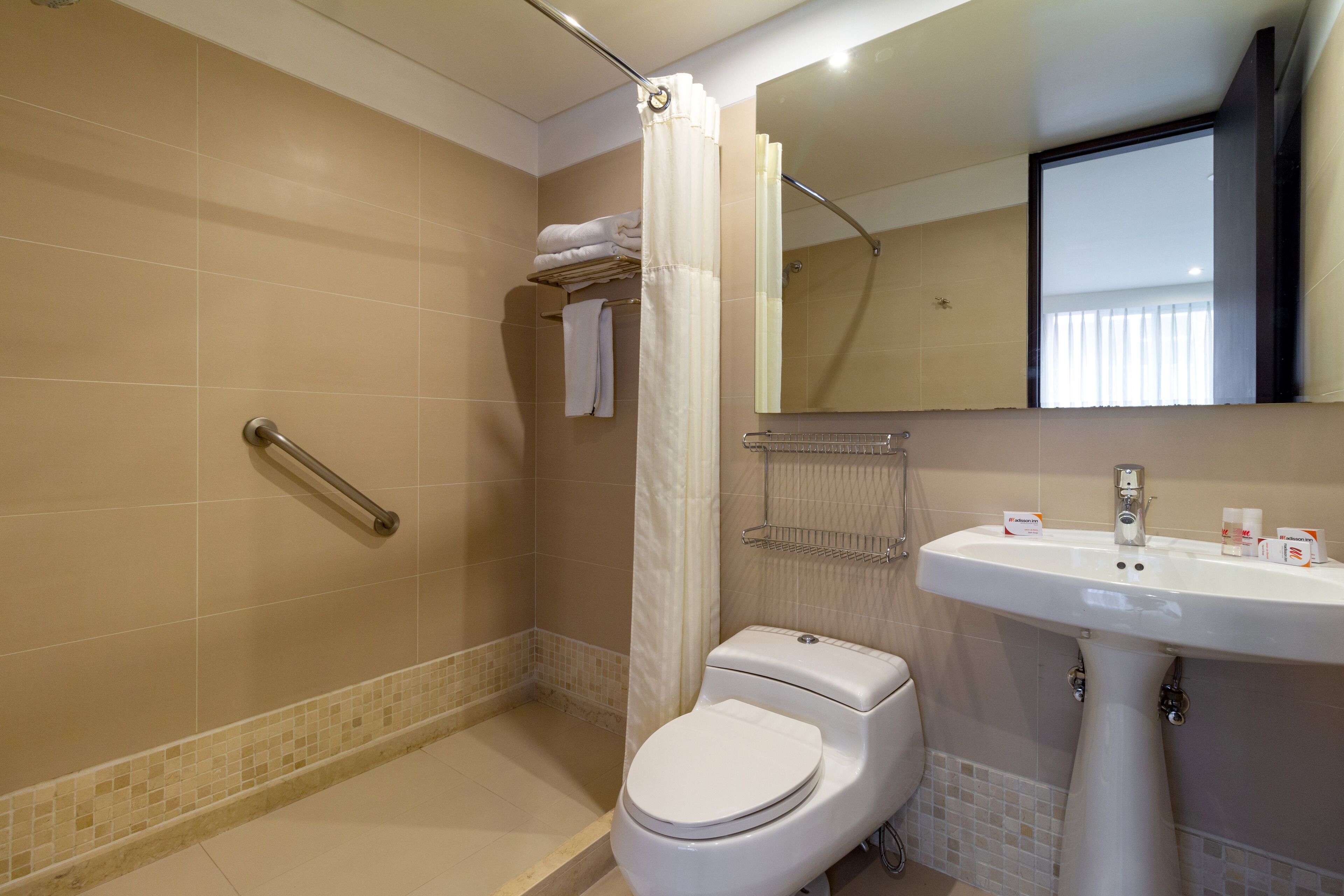 A bathroom with a shower, toilet, and sink.