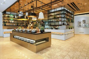 A modern kitchen with a central island, pendant lighting, and a variety of kitchenware on shelves. - Fujairah Rotana Resort & Spa (Al Aqah)