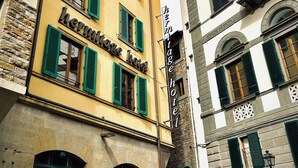 A multi-story building with a yellow facade and green shutters, labeled as "Hermitage Hotel." - Hotel Hermitage (Florence)