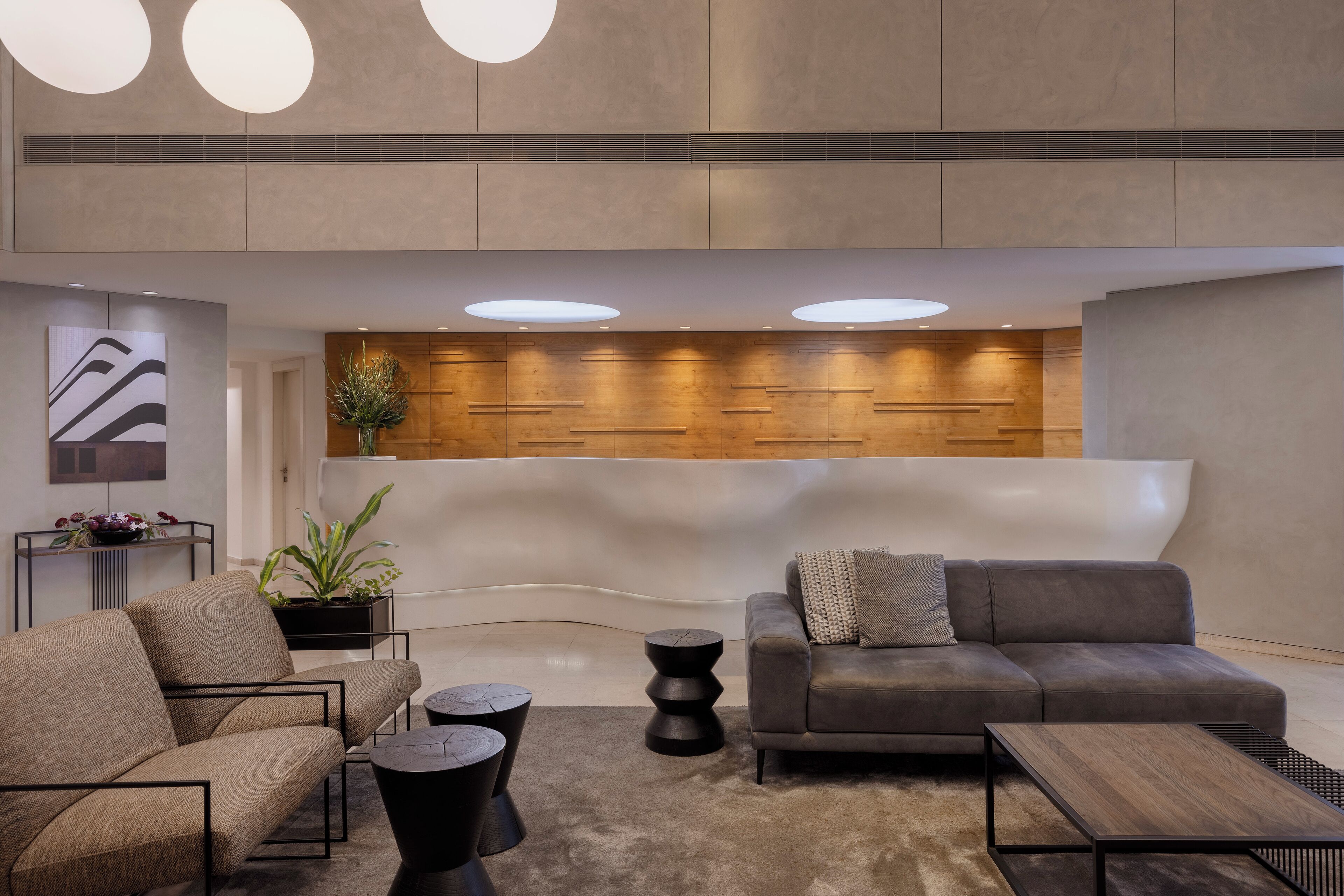 A modern lobby with a reception desk, sofas, and a coffee table.