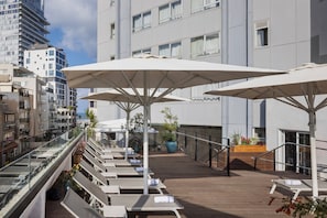 Una piscina al aire libre de temporada, sombrillas
