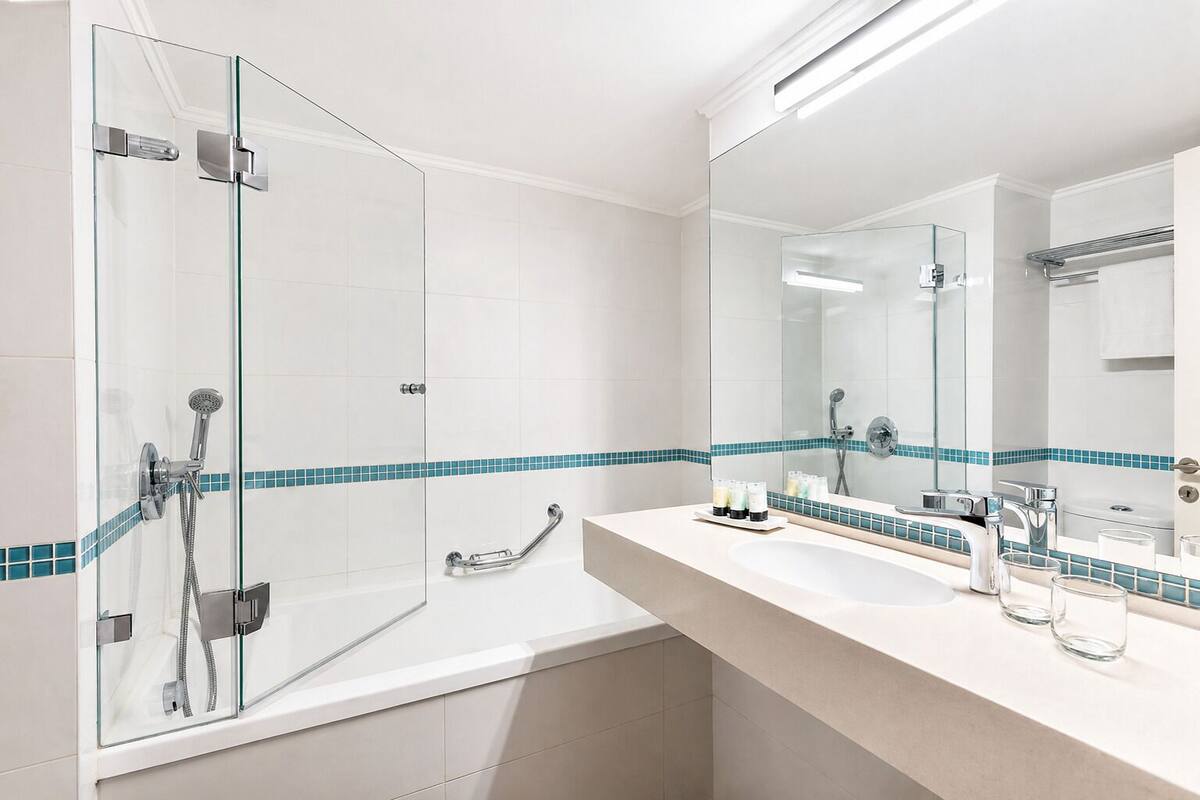 A modern bathroom with a glass shower enclosure, a bathtub, a vanity with a sink and mirror, and a towel rack.