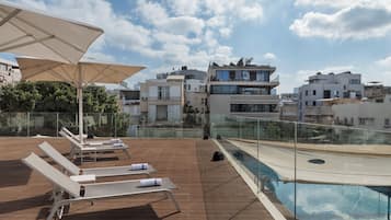 Alberca al aire libre por temporada y sombrillas en la alberca