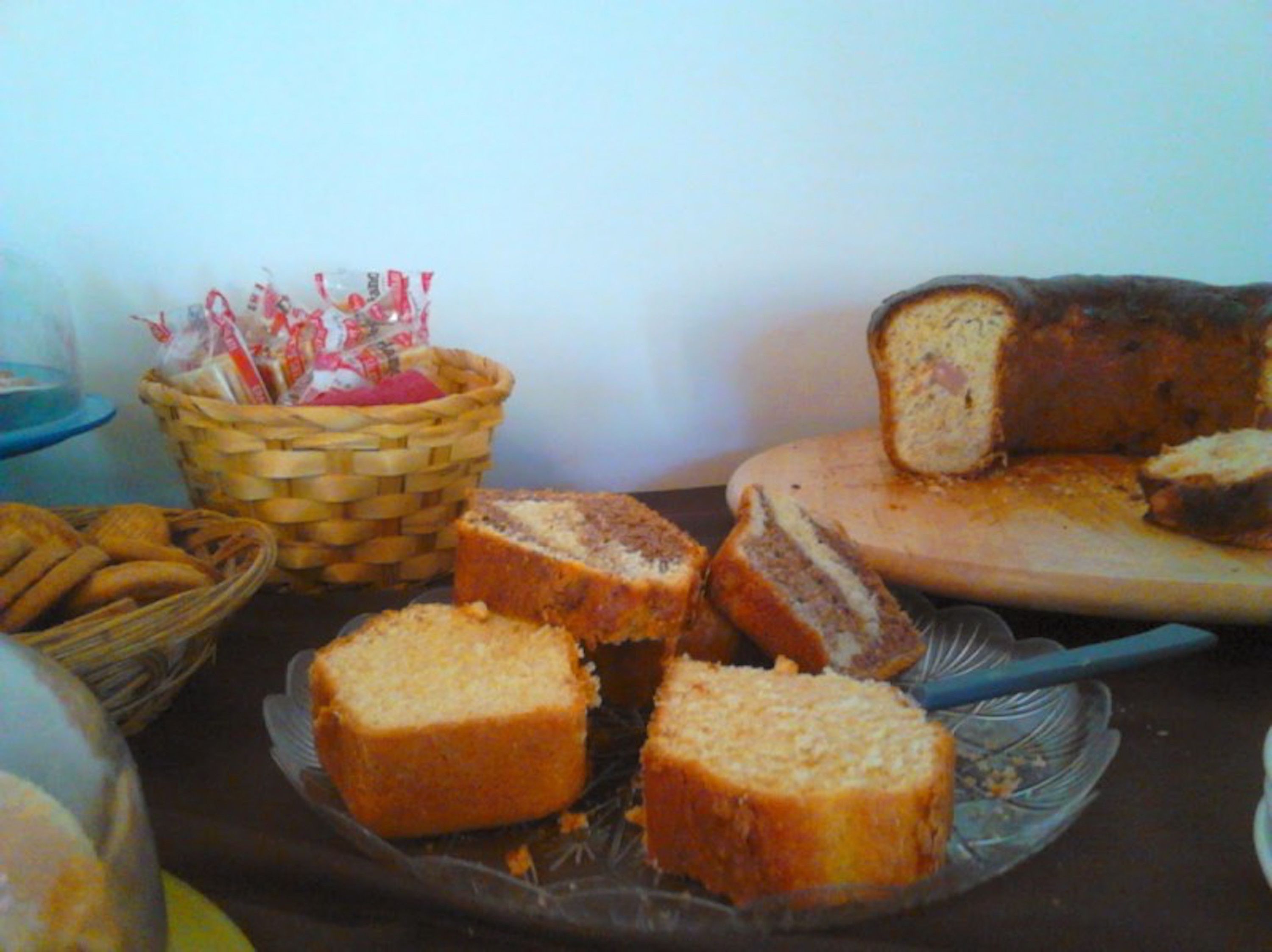 Una mesa con diferentes panes y pasteles, incluyendo un pan con relleno visible.