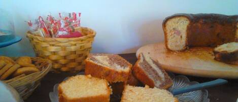 A table with various types of bread and pastries, including a loaf with visible filling.