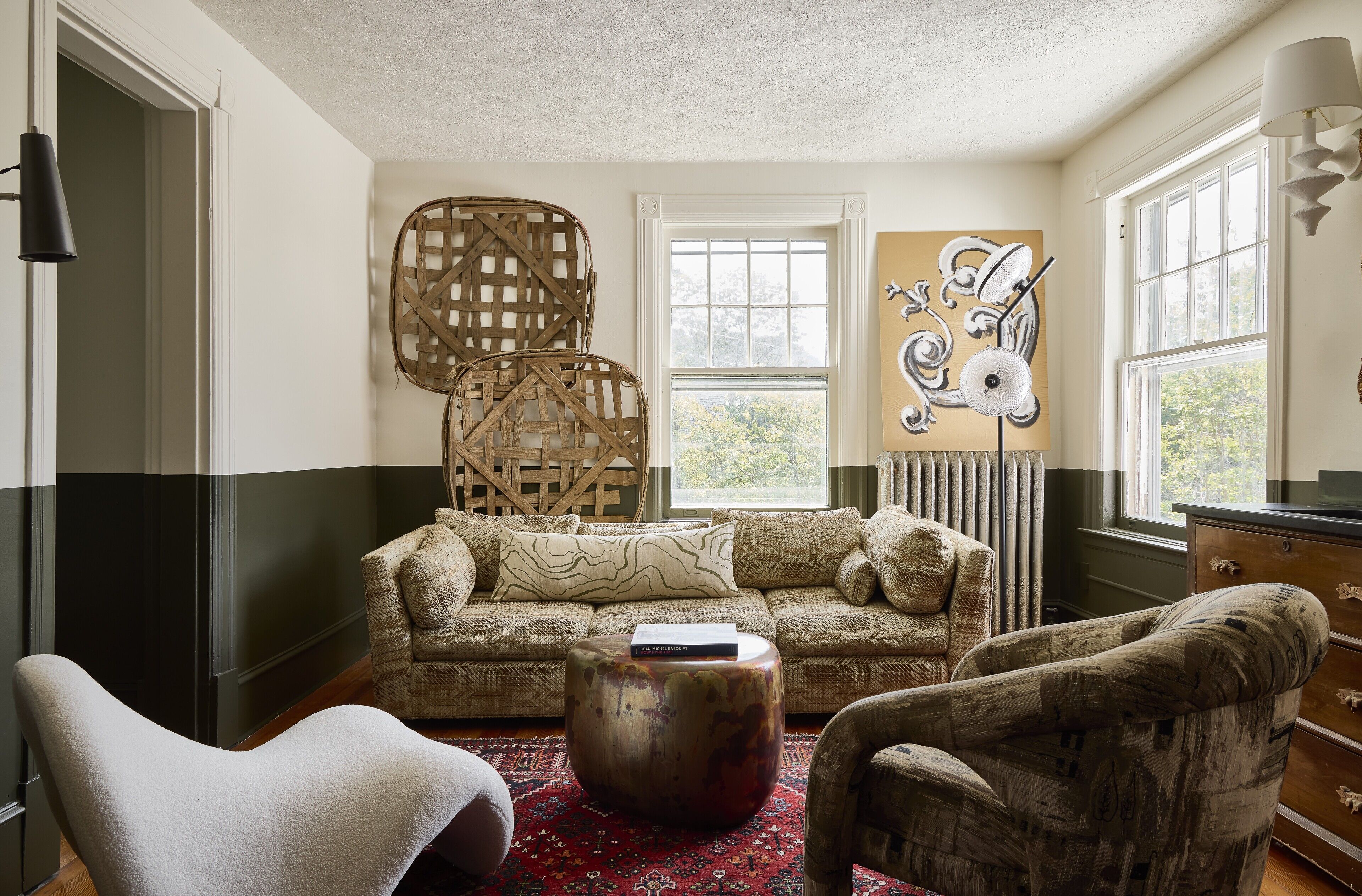 A cozy living room with a sofa, two armchairs, a coffee table, and a large woven chair.