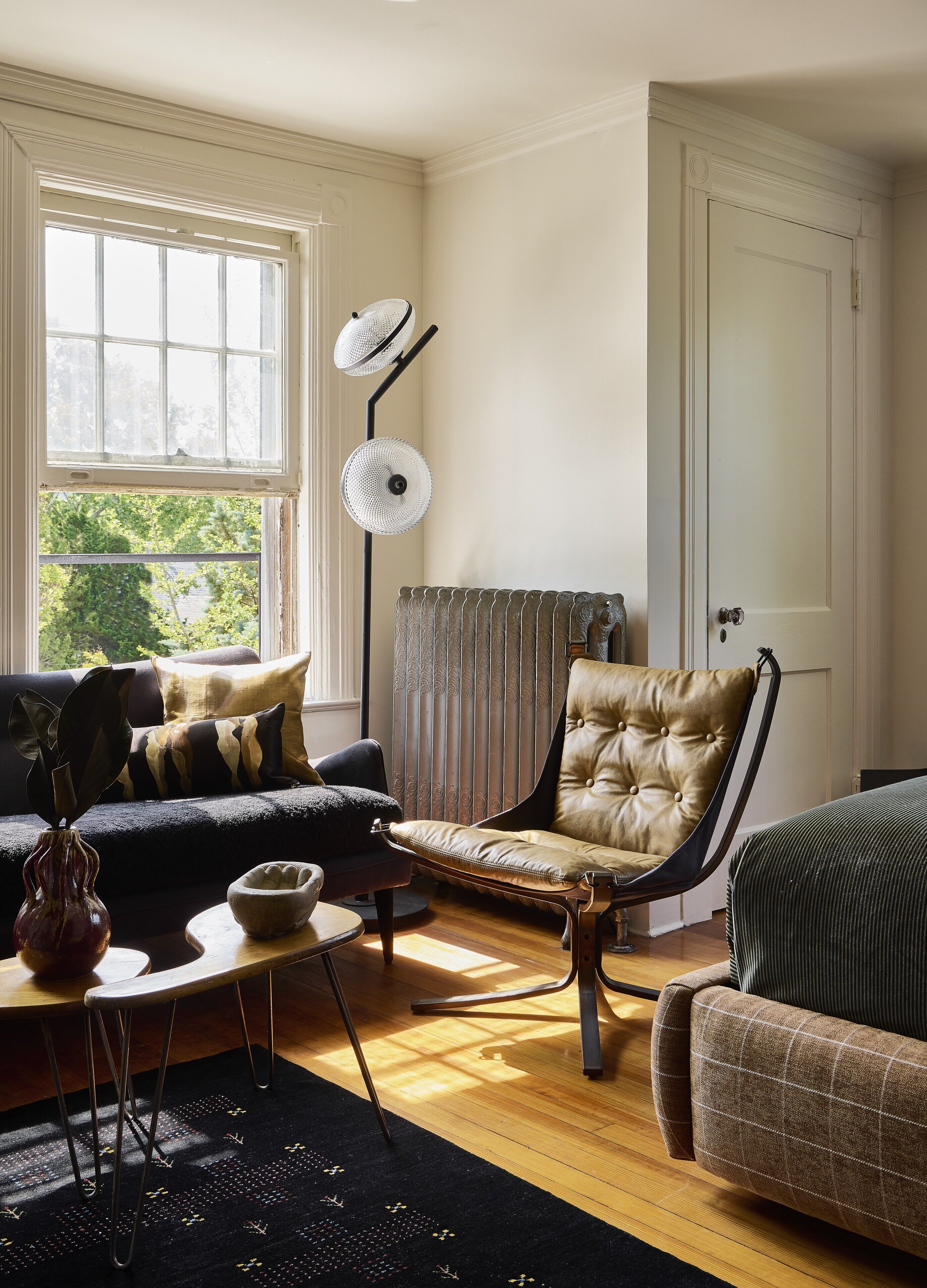 Un salon comprenant un canapé, des fauteuils, une table basse et un radiateur.