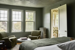 Relax in this serene space with a large bed, comfortable chair, and a reading nook.