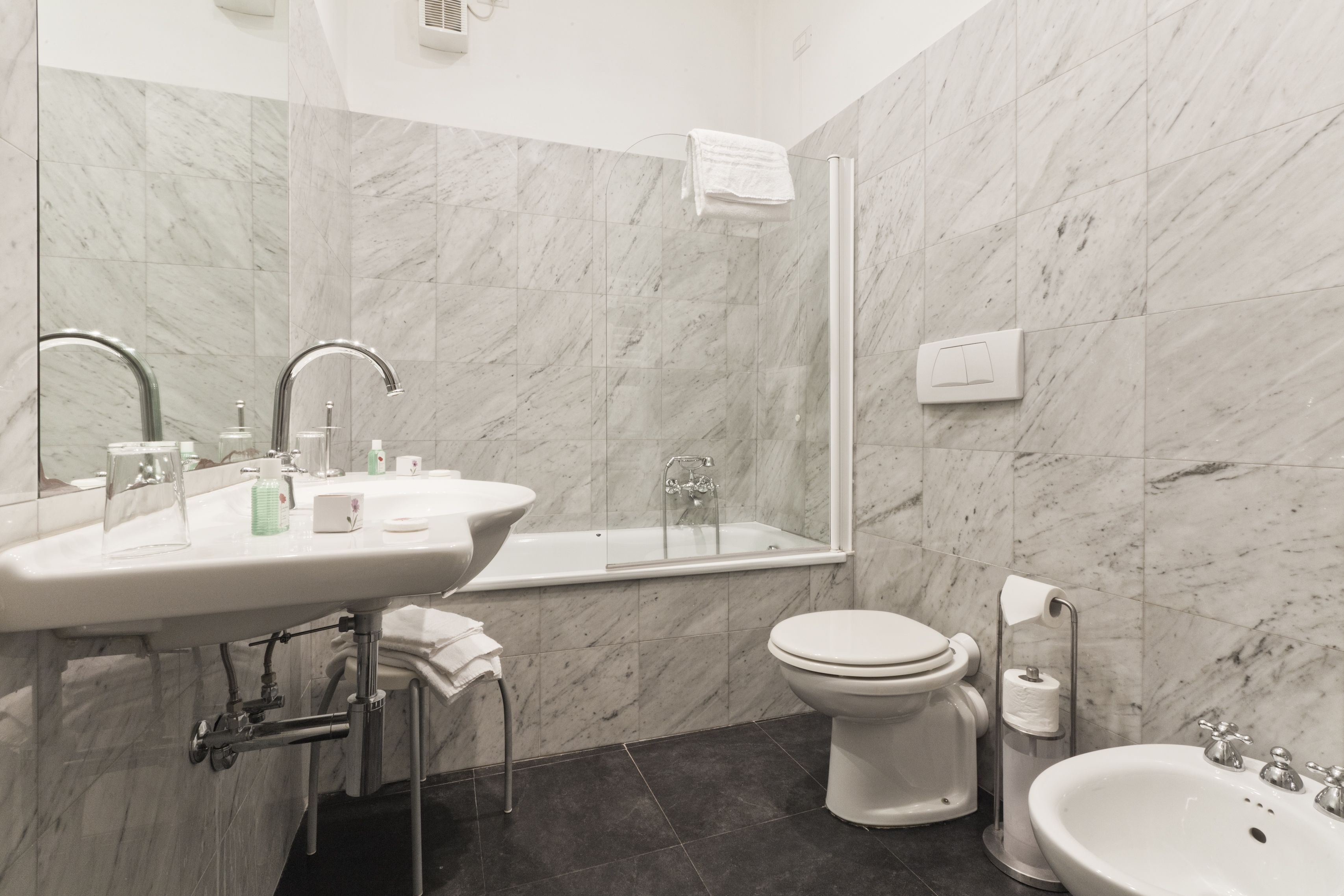 Et moderne badeværelse med vask, toilet og badekar.