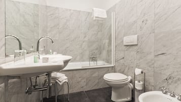 Et moderne badeværelse med vask, toilet og badekar.