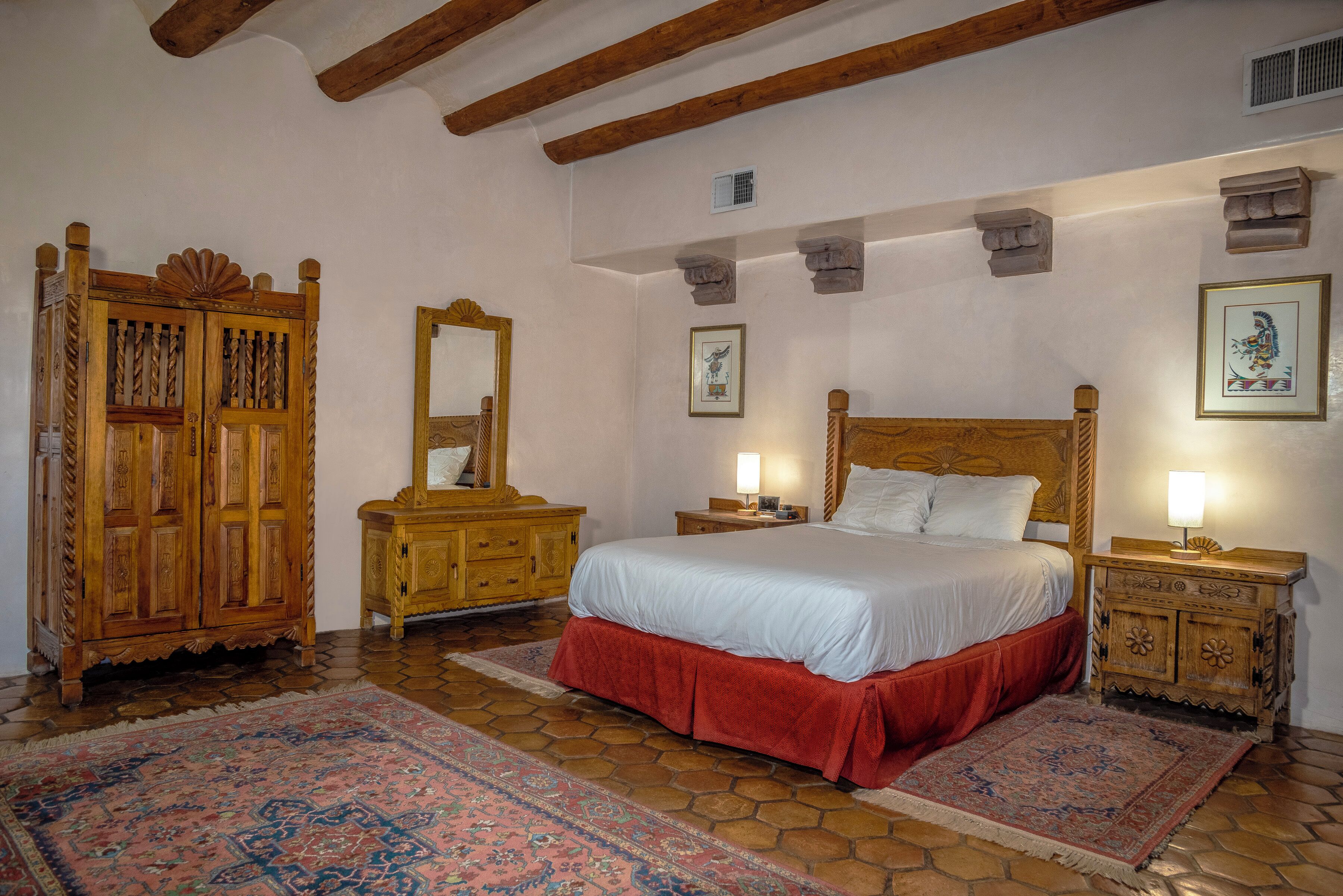 Une chambre à coucher de style traditionnel, avec un lit en bois, un grand miroir et une armoire en bois.