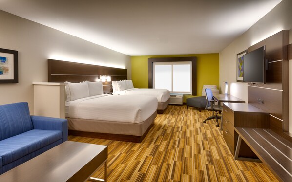 Een hotelkamer met twee bedden, een bureau, een stoel, een televisie en een groot raam.