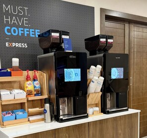 A coffee station with multiple coffee machines, labeled 'Costa Coffee', and a sign that reads 'MUST. HAVE. COFFEE EXPRESS'. There are also coffee pods, a coffee maker, and a display of disposable cups. - Holiday Inn Express Hotel & Suites El Paso I-10 East by IHG (El Paso)