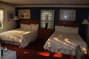 A hotel room with two beds, a wooden dresser, a mirror, and framed artwork on the walls. - Northside Motel (Williamstown)