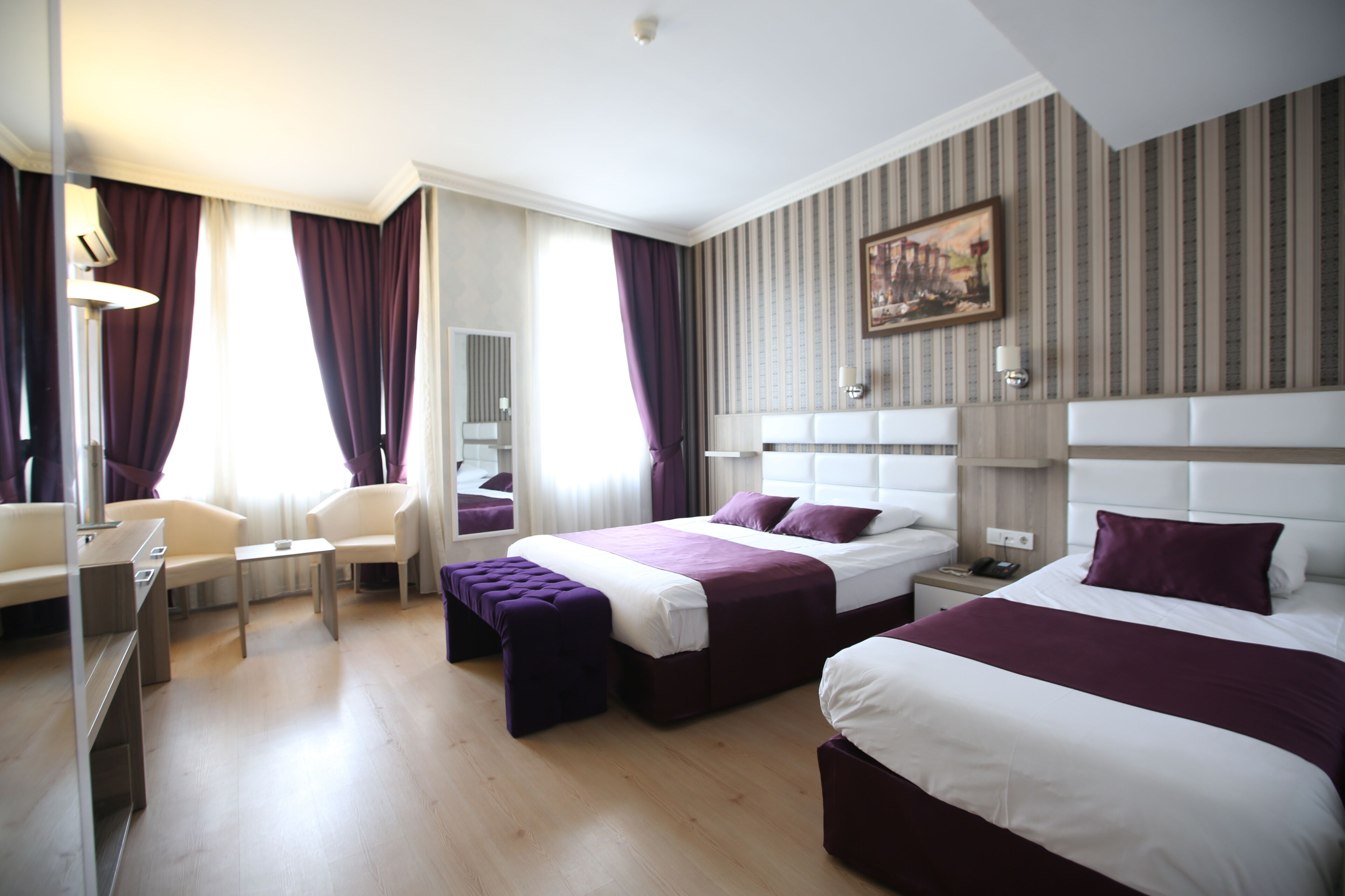 Habitación de hotel con dos camas, un escritorio y una silla.