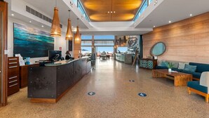 A modern lobby with a reception desk, seating area, and artwork.