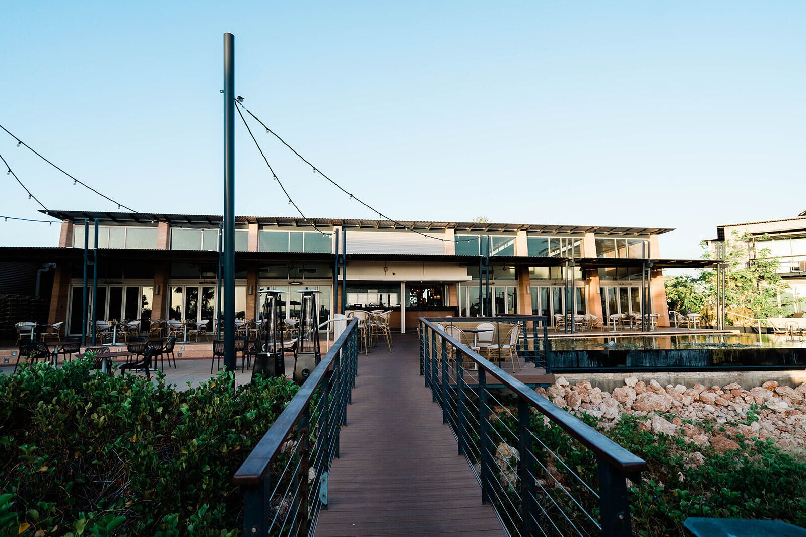 A modern building with outdoor seating and a pool.