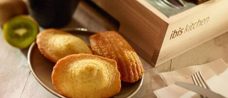 A plate of pastries, a cup of coffee, and a wooden box labeled "ibis kitchen".