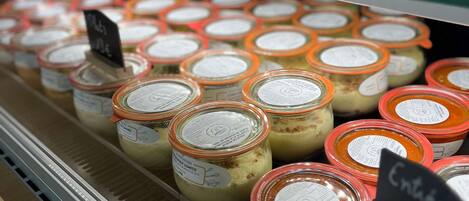 Vitrine refrigerada com potes de produtos alimentícios, alguns com preços indicados.