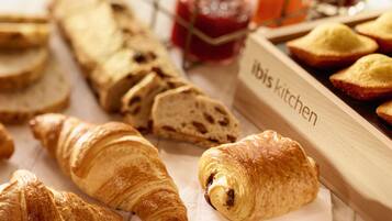 Une variété de produits de boulangerie, notamment des croissants et du pain, avec une étiquette indiquant « Cuisine ibis ».