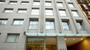 A modern hotel building with a prominent entrance, large windows, and a sign reading "SV BUTLER VIENNA". - Suites Viena Plaza de España (Madrid)