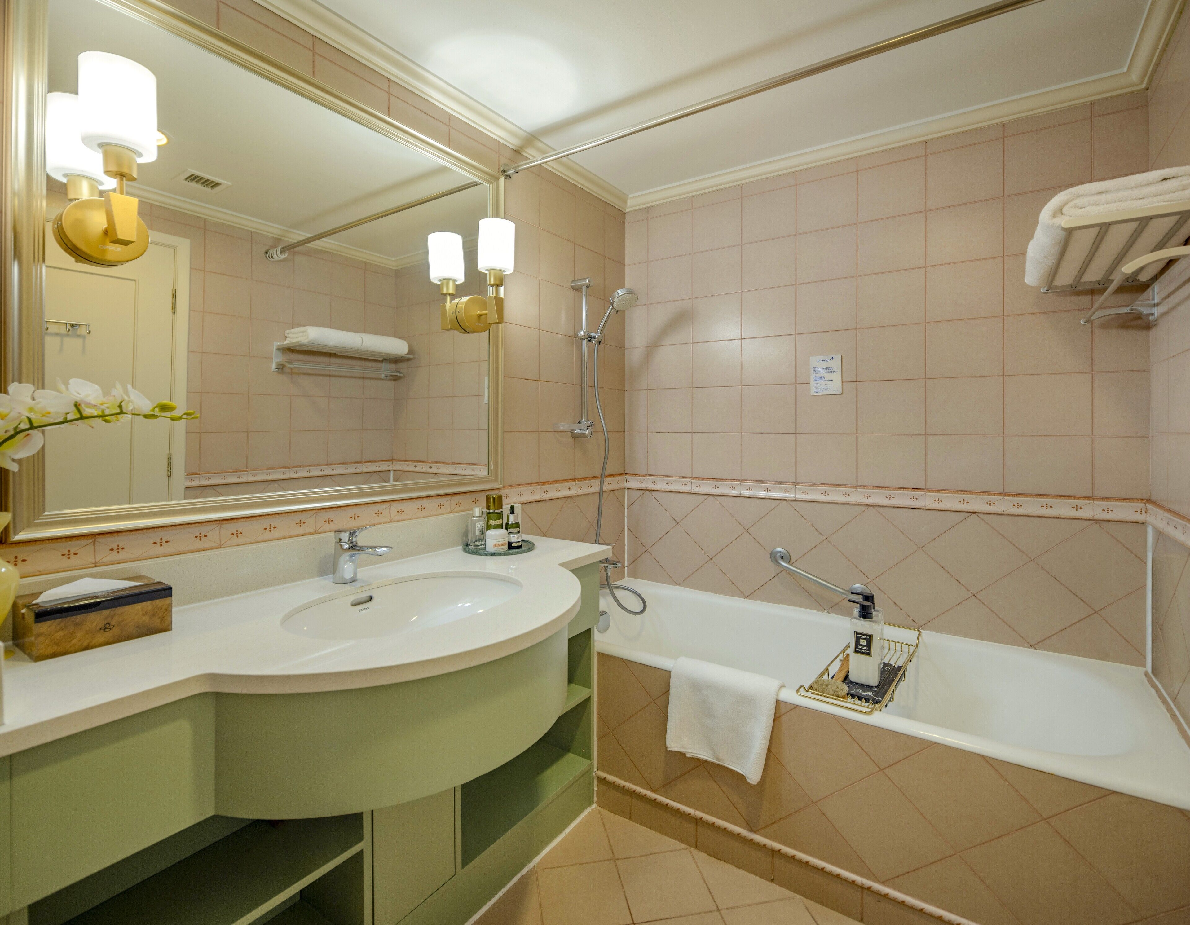 A bathroom with a large mirror, a sink, a bathtub, and a shower.