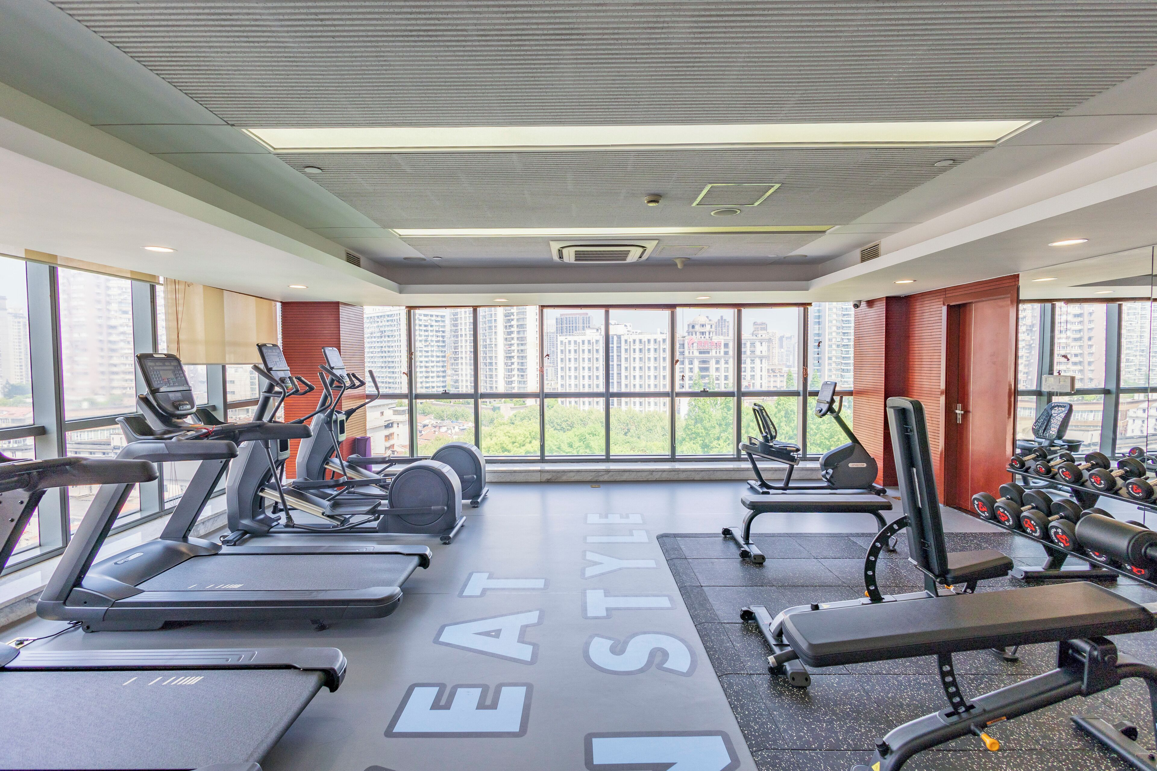 Et moderne fitnesscenter med løbebånd, styrkemaskiner og håndvægte.