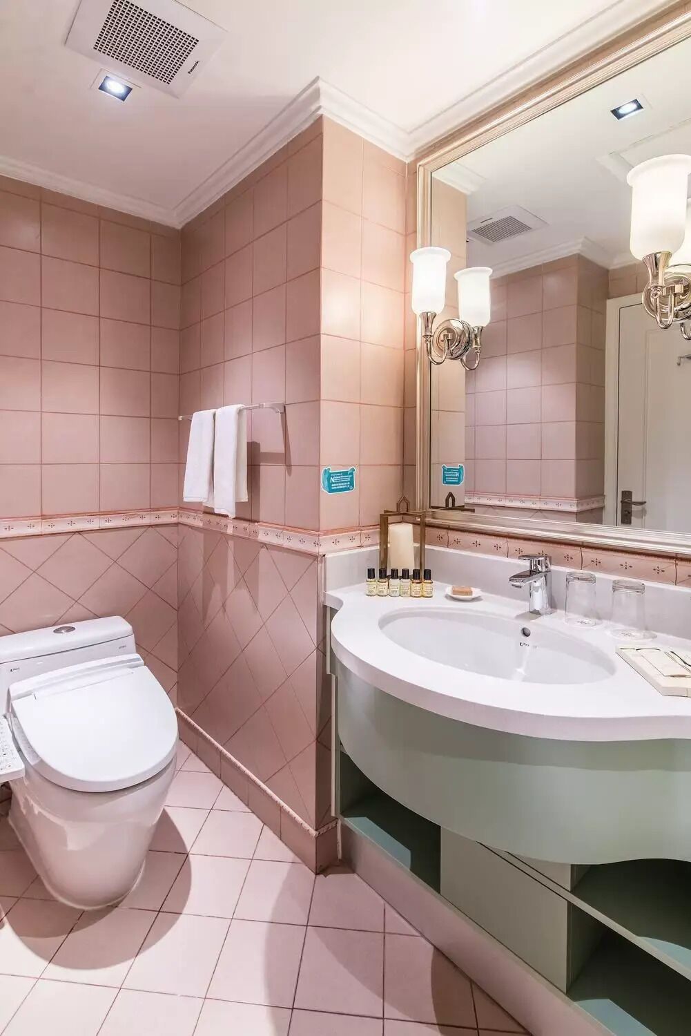 Un baño con inodoro, lavamanos y espejo.