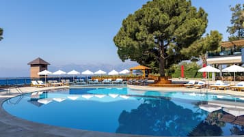 Piscine couverte, piscine extérieure, parasols de plage, chaises longues