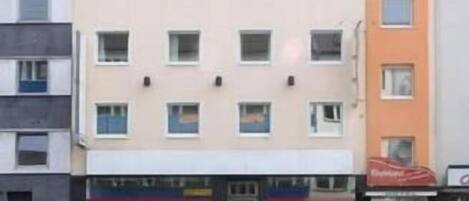 Un edificio de varios pisos con una fila de ventanas en la planta baja, probablemente un hotel o un complejo de apartamentos.