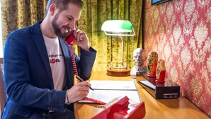 A man at a desk with a telephone, a lamp, and a bust sculpture. - Hotel Rheinland (Bonn)