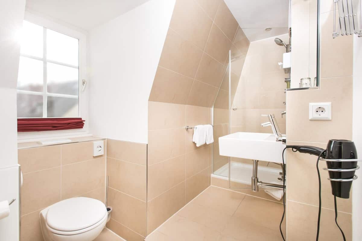 shower, hair dryer, slippers, towels