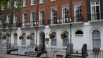 Classic brick building with arched windows and a symmetrical facade, offering secure accommodations at MENTONE HOTEL.