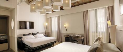 A hotel room with a large bed, a desk, a chair, and a TV mounted on the wall.