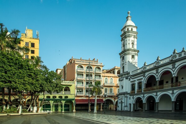 A plaza with historic buildings, including a prominent white tower and a yellow building with balconies. - Hotel Imperial (Veracruz)
