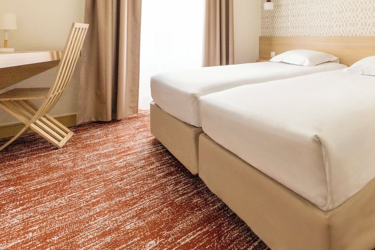 Una habitación de hotel con cama, escritorio y silla.