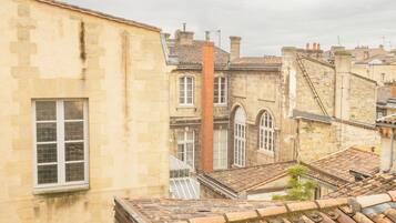 A historic building with a stone facade, a visible chimney, and a traditional tiled roof.