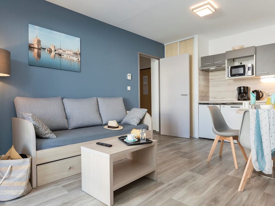 Una sala de estar moderna con un sofá, una mesa de centro y un comedor con sillas y una mesa.