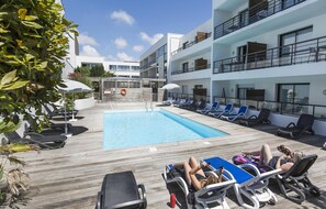 Piscine extérieure en saison, parasols, chaises longues