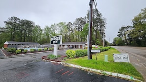 Un motel con un cartel que dice "BUDGET INN" y un cartel que indica "ENTRADA".