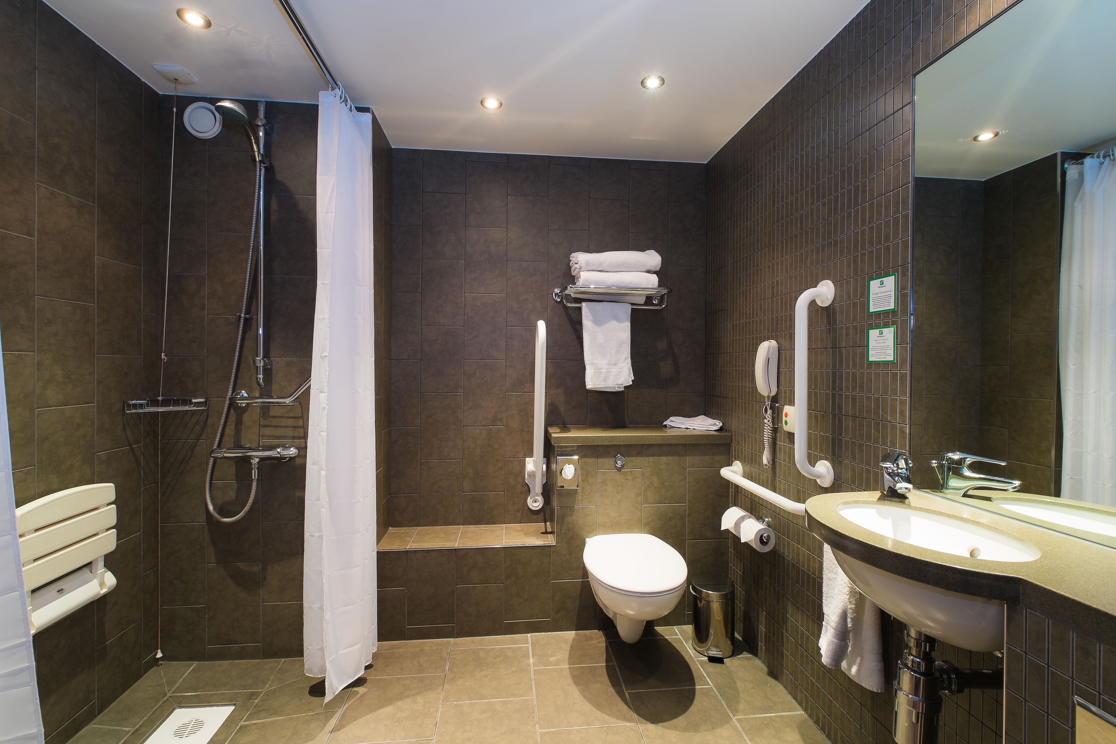 Un baño moderno con ducha, inodoro y lavamanos.