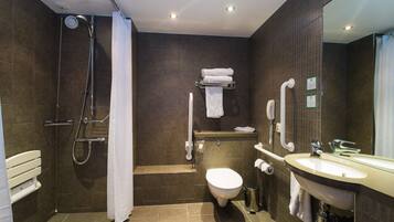 Un baño moderno con ducha, inodoro y lavamanos.
