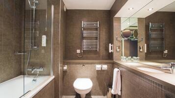 Een moderne badkamer met een douchecabine van glas, een toilet en een wastafel met spiegel.