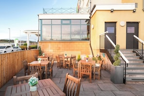 Relax on the patio with a view, surrounded by lush greenery and comfortable seating.